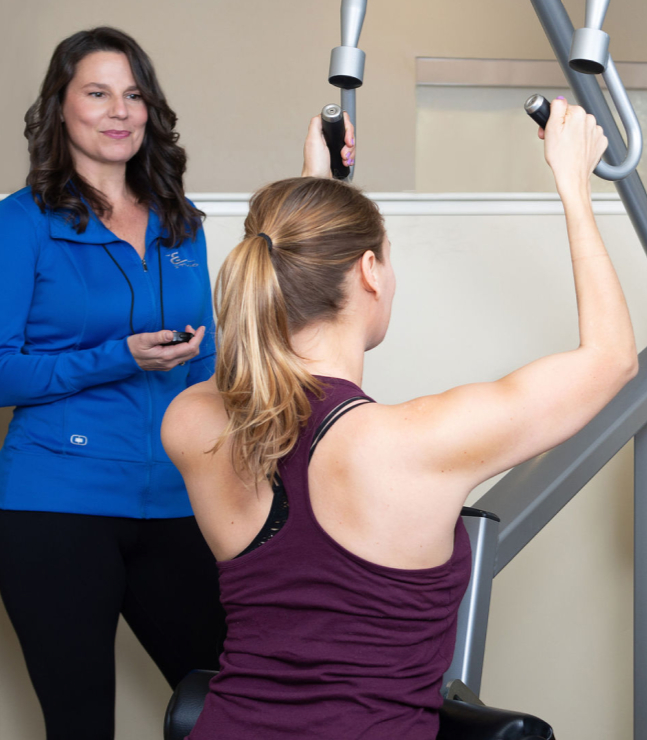 Bonnie training Dana on a Matrix strength machine in the studio.