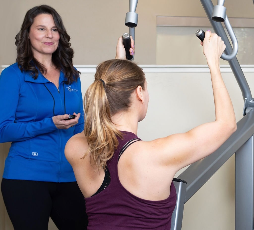 An E Studio trainer coaching a client through a slow, controlled repetition.