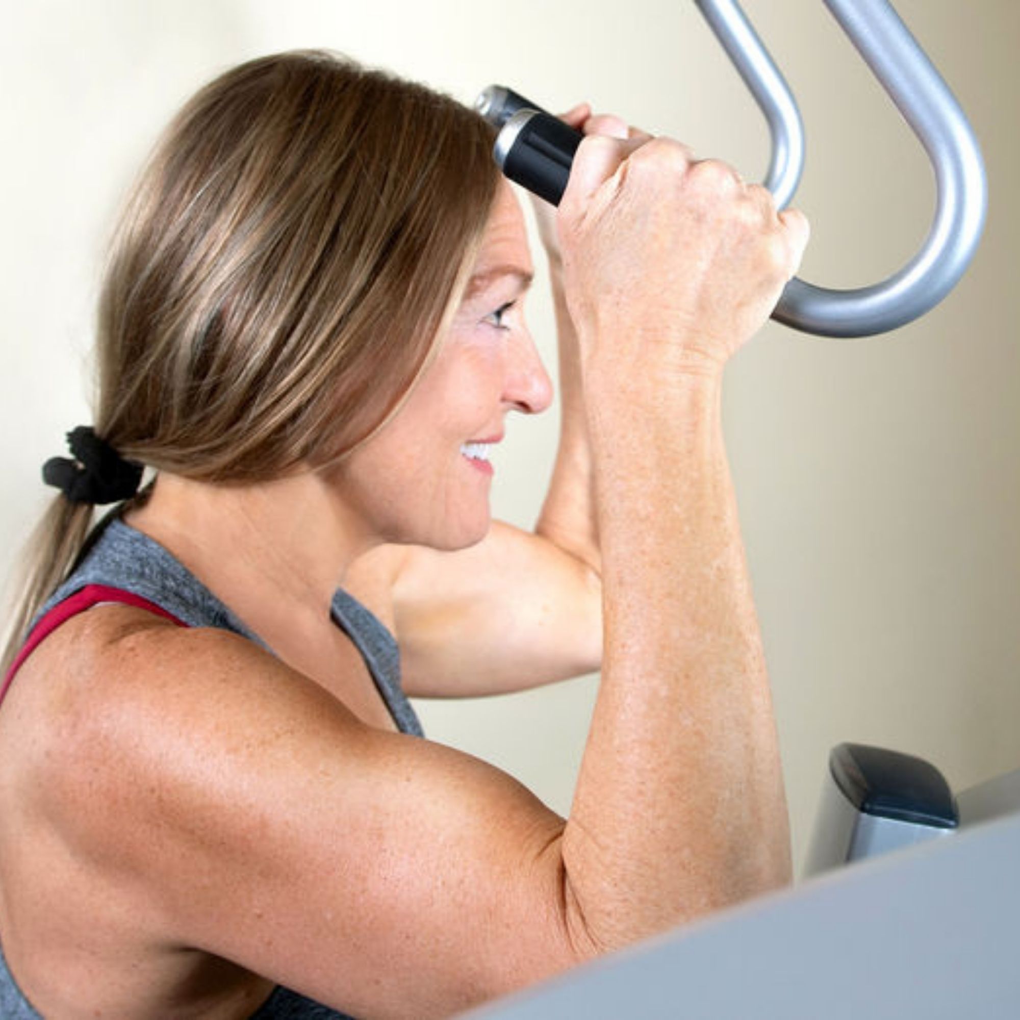 A woman over 50 showing the strength built through SuperSlow training at E Studio.